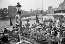 841931 Gezicht op het water tussen het Stationsplein en de Prins Hendrikkade te Amsterdam, met een rondvaartboot.